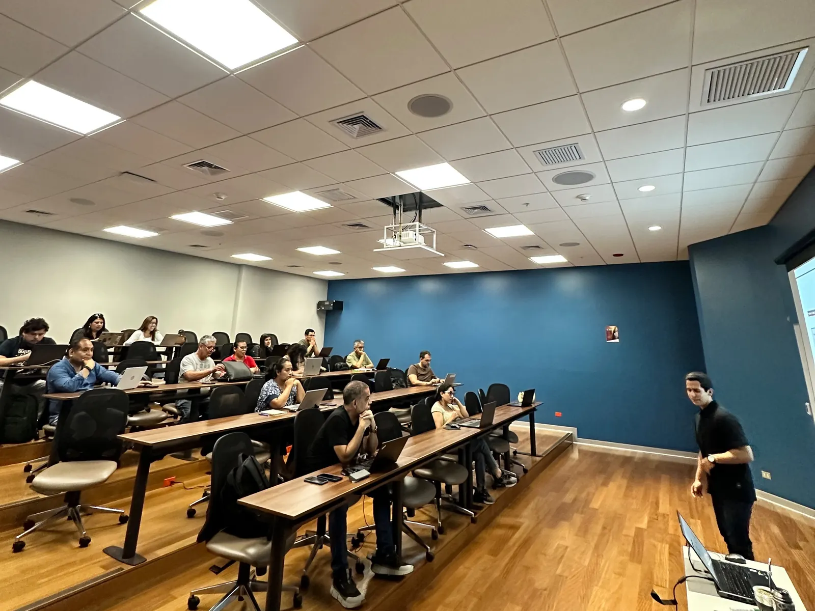 Sala llena en el taller Claude para Negocios con APEM, cada asistente con su laptop